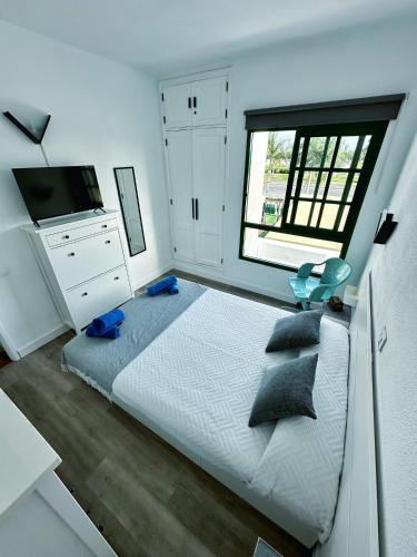a bedroom with a large bed and a window at Bungalow Yaipe in Maspalomas