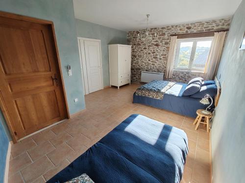 a bedroom with two beds and a window at La Source Du Bonheur Chambres et Table d'Hôtes in Rieupeyroux