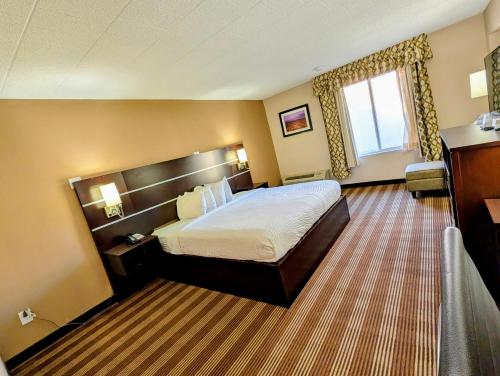 a hotel room with a bed and a window at Pocono Inn & Banquet - Stroudsburg in Delaware Water Gap