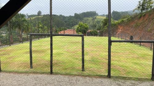 a chain link fence with a field of grass at Casa do Campo in Rio do Sul