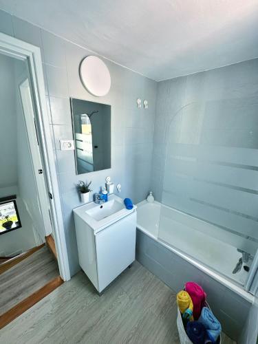 a bathroom with a white tub and a sink at Bungalow Yaipe in Maspalomas