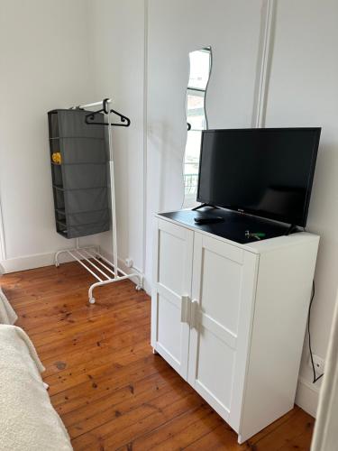 a white cabinet with a tv on top of it at Garden Campo de Ourique Guest House - Hostel in Lisbon