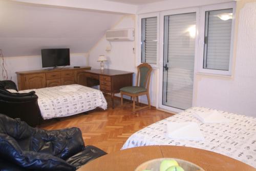 a room with two beds and a desk with a television at Spacious 2Bedroom Flat Budva Becici in Boreti