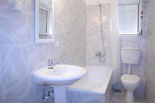 a white bathroom with a sink and a toilet at Spacious 2Bedroom Flat Budva Becici in Boreti