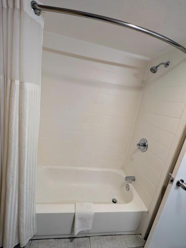 a bath tub in a bathroom with a shower curtain at Pocono Inn & Banquet - Stroudsburg in Delaware Water Gap