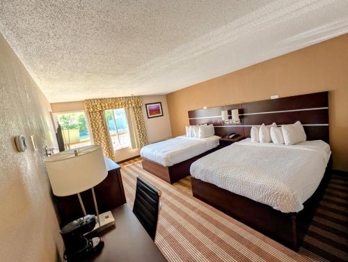 a hotel room with two beds and a lamp at Pocono Inn & Banquet - Stroudsburg in Delaware Water Gap