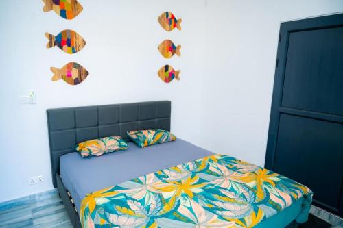 a bedroom with a bed with colorful sheets and pillows at Villa Boulevard Paradise in Grand Baie