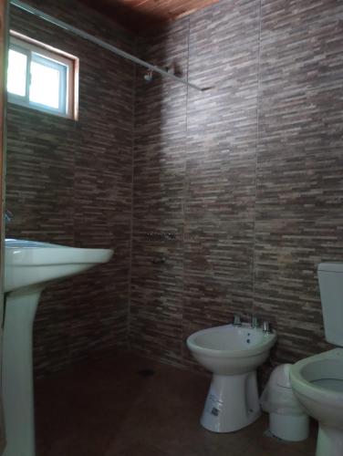 a bathroom with a sink and a toilet and a window at Los 3 soles in Villa Ciudad Parque