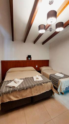 a bedroom with two beds and a ceiling at Ribera Sur Hotel - Los Algarrobos - Tanti in Tanti