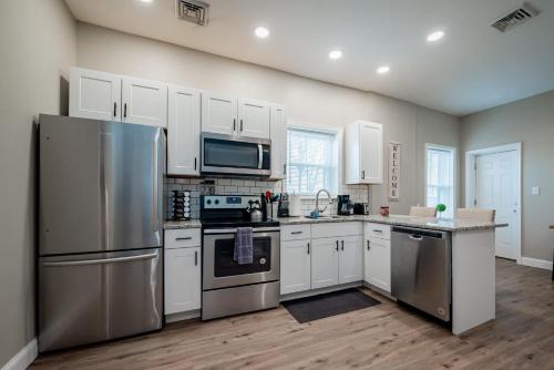 a kitchen with stainless steel appliances and white cabinets at The Penthouse at Park Place King bed fast WIFI and free coffee in Wilmington
