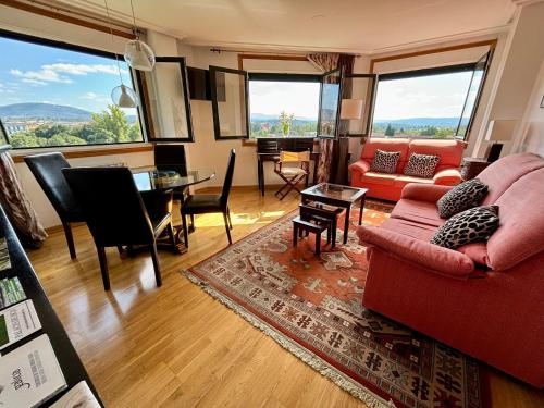 a living room with a red couch and a table at El Rincón de Muxiña in Monforte de Lemos