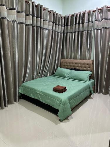 a bed in a room with curtains in a room at SaRa Homestay in Kuala Terengganu