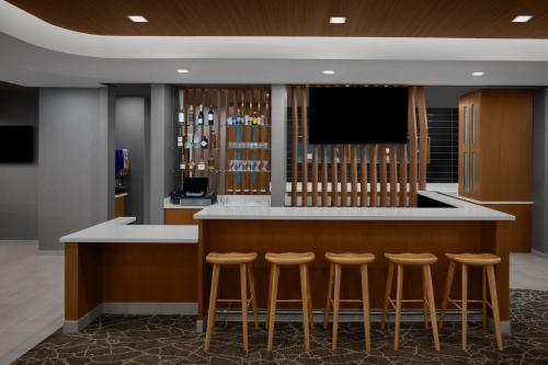 a bar with stools and a flat screen tv at SpringHill Suites by Marriott Grand Rapids Airport Southeast in Cascade