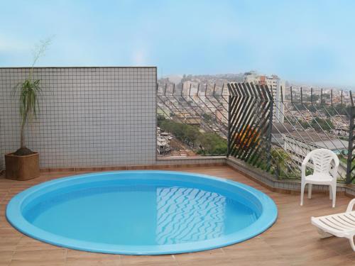 uma banheira de hidromassagem numa varanda com vista para a cidade em Maxim Plaza Hotel em Juiz de Fora