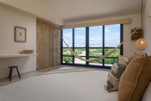 a bedroom with a large window with a view at Ikana Puerto Aventuras Golf Getaway in Puerto Aventuras