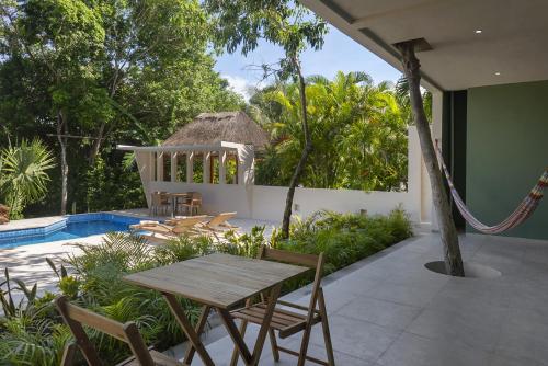 a patio with a table and chairs next to a pool at Ikana Puerto Aventuras Golf Getaway in Puerto Aventuras