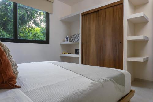 a bedroom with a bed and a wooden cabinet at Ikana Puerto Aventuras Golf Getaway in Puerto Aventuras