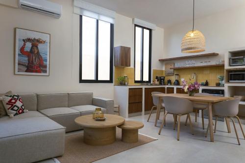 a living room with a couch and a table and a kitchen at Ikana Puerto Aventuras Golf Getaway in Puerto Aventuras