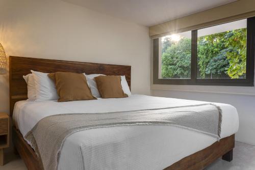 a bedroom with a large bed with a window at Ikana Puerto Aventuras Golf Getaway in Puerto Aventuras
