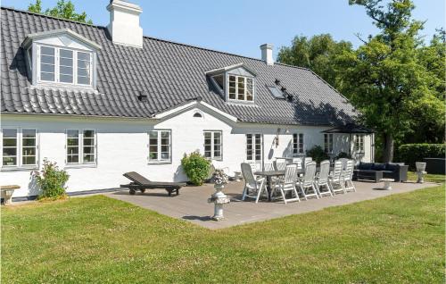 a white house with a picnic table and chairs at Drostgården in Humble