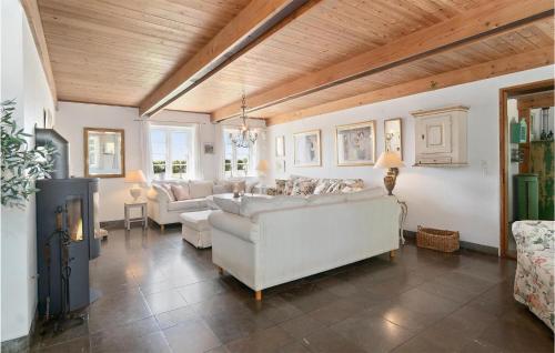 a living room with white furniture and a wooden ceiling at Drostgården in Humble