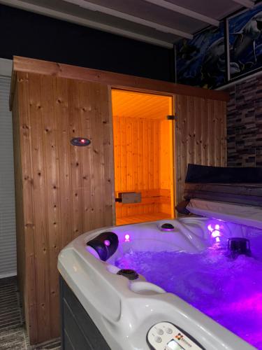 a jacuzzi tub with purple lighting in a room at Penthouse Exclusive in Pristina