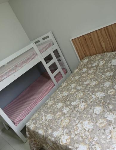 a bedroom with two bunk beds and a stool at Apartamento com varanda - Sahy in Mangaratiba