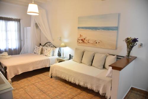 a bedroom with two beds and a painting on the wall at Stefanos Katsaros Studios in Skala