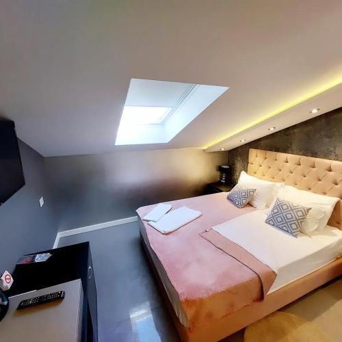 a bedroom with a large bed with a skylight at Vazdušna Banja in Niš