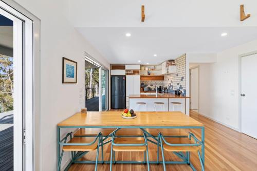 a kitchen and dining room with a wooden table and chairs at The Retreat at Moruya in Moruya