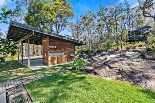 a log cabin in the middle of a yard at The Retreat at Moruya in Moruya