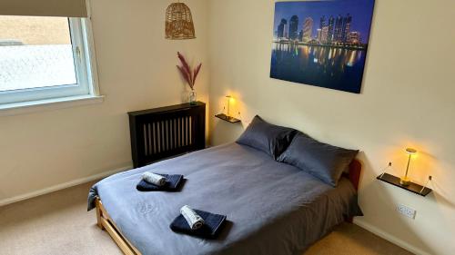 a bedroom with a bed with two towels on it at The Red Door, Two-Bedrooms Apartment in Edinburgh
