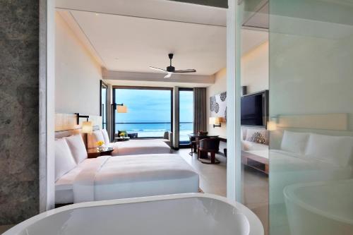 a bedroom with two beds and a view of the ocean at Weligama Bay Marriott Resort & Spa in Weligama