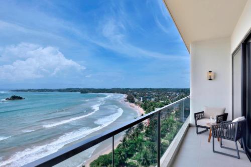 a balcony with a view of the ocean at Weligama Bay Marriott Resort & Spa in Weligama