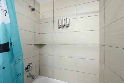 a bathroom with a shower with a blue shower curtain at Stylish 1BR Apt - Steps from NRG and Texas Med Center in Houston