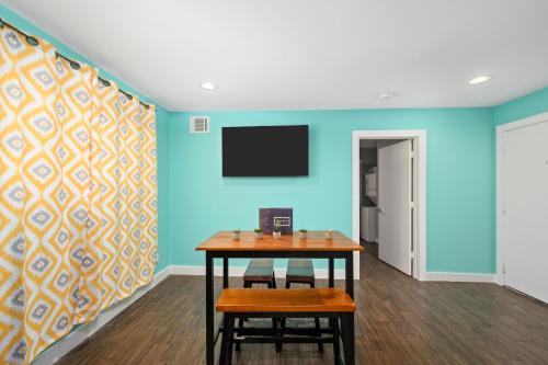 a room with a table and a tv on a wall at Stylish 1BR Apt - Steps from NRG and Texas Med Center in Houston