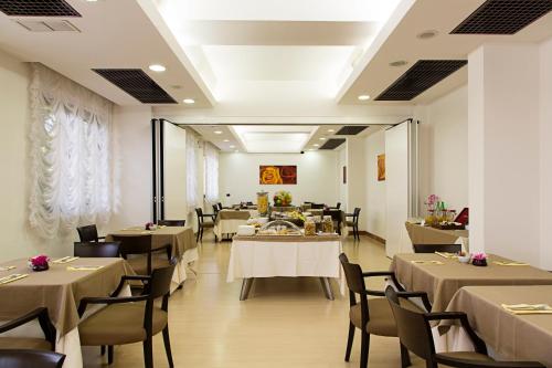 un restaurante con mesas y sillas en una habitación en Hotel Palace 2000, en Pomezia