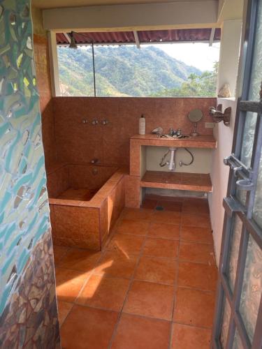 a bathroom with a tub and a sink with a window at Sky Temple Yelapa in Yelapa