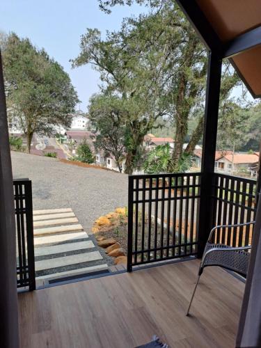 a screened in porch with a chair and stairs at Cabana do Mato Waldhütte in Treze Tílias