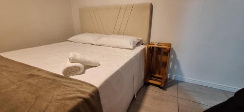 布卢梅瑙SUITE COM AR e BWC PRIVATIVO POUCOS METROS OKTOBERFEST的一间卧室，床上有两条毛巾