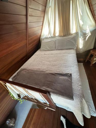 a bed in a small room with a canopy at Chalé Maloca in Cariry