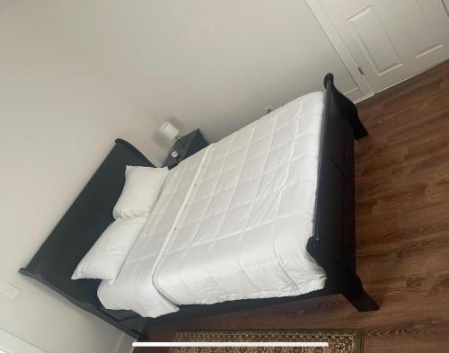 a bed with white sheets and pillows in a room at Quiet private room in Fall River