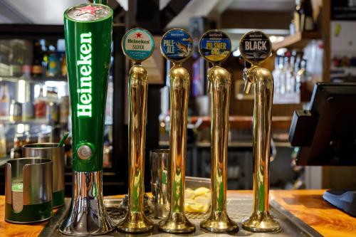 a row of gold spoons sitting on a bar at The Brown Pub in Methven