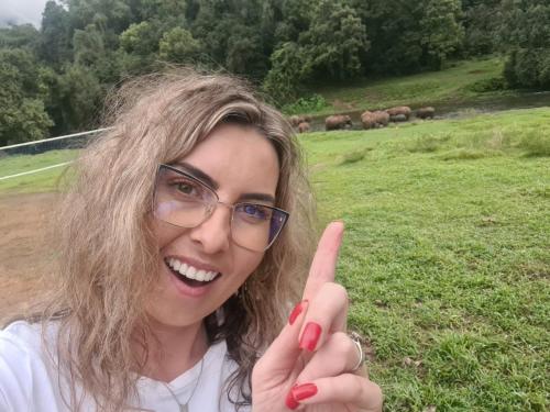a woman with her index finger up in a field at Forestscape Resort Munnar in Munnar