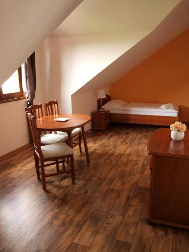 a room with a table and chairs and a bed at Penzion Mušlov in Mikulov