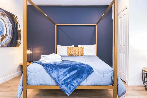 オーランドにあるNEW5 APT NrUCF PETSOK PRIVATE patioENTRY LAUNDRYの青い壁のベッドルーム1室(天蓋付きベッド1台付)