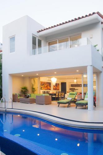 a villa with a swimming pool in front of a house at Marival Distinct All-Suites & World Spa - Handwritten Collection in Nuevo Vallarta 