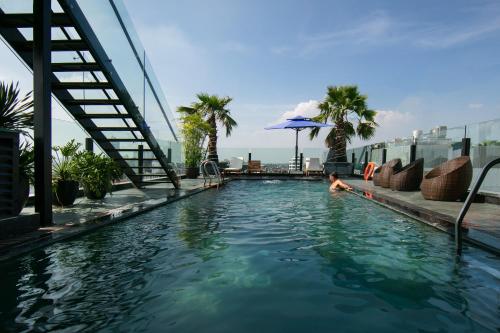 a person in a swimming pool with an umbrella at MAY DE VILLE Crown Hotel in Hanoi