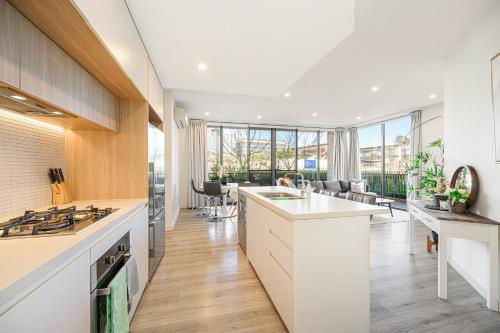 a kitchen with white counters and a large window at Penrith 3Br apt close toTrain station & Shopping in Penrith