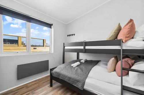 a bedroom with a bunk bed and a window at Þingvallavatn Hot Tub Sauna 2024 Built Cabin in Veiðilundur